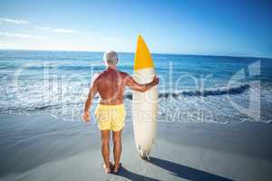 Senior man posing with a surfboard