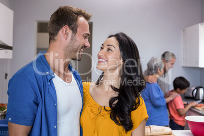 Young man and young woman standing in kitchen
