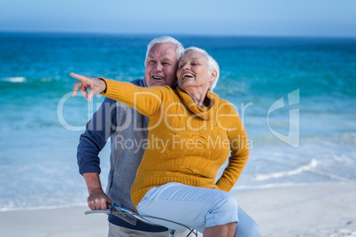 Senior couple with a bike pointing