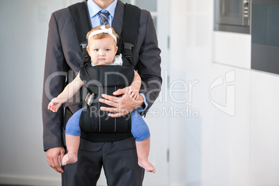 Businessman carrying cute daughter at home