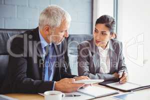 Businessman and businesswoman sitting in conference room