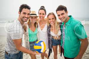 Group of friends with beach ball having fun on the beach