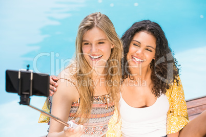 Beautiful women taking a selfie by swimming pool