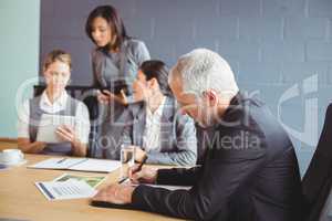 Businessman writing a report in conference room