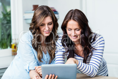 Happy friends watching video on digital tablet