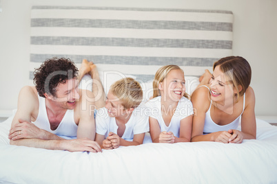 Happy family relaxing on bed