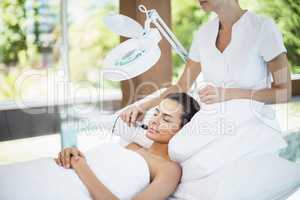 Smiling woman receiving facial massage