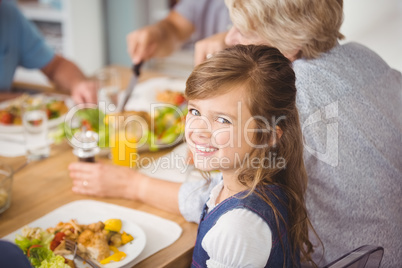 Happy girl having breakfast with family
