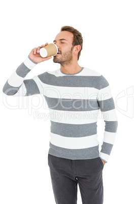 Happy young man in winter wear having coffee