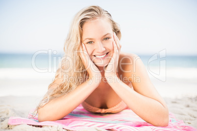 Happy woman in bikini lying on the beach
