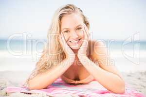 Happy woman in bikini lying on the beach