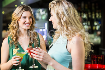 Smiling friends drinking cocktails