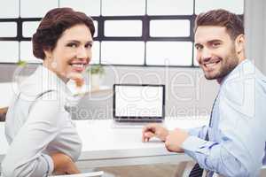 Happy business people sitting at laptop desk