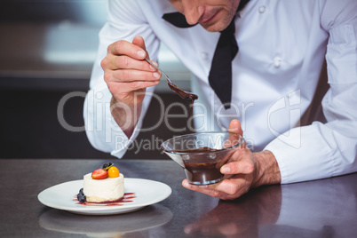 Chef putting chocolate sauce on a dessert