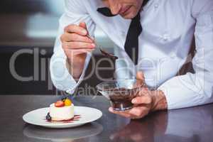 Chef putting chocolate sauce on a dessert