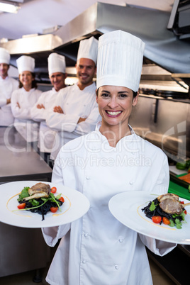 Team of chefs with one presenting dishes