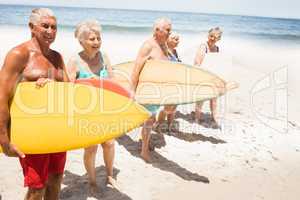 Senior friends holding surfboard