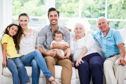 Portrait of smiling family with grandparents while sitting on so Portrait of smiling family with grandparents while sitting on so
