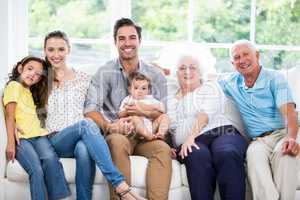 Portrait of smiling family with grandparents while sitting on so