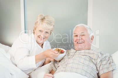 Happy senior couple having breakfast in bed