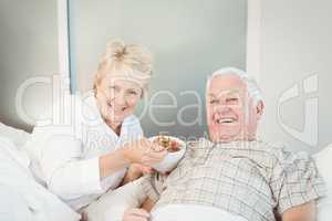 Happy senior couple having breakfast in bed