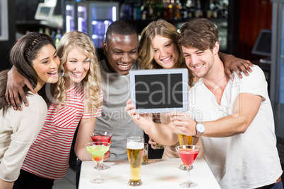 Happy friends taking selfie with tablet