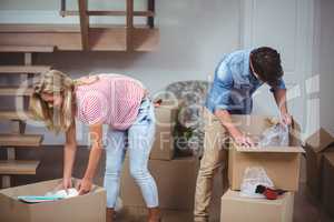 Couple unpacking boxes at new house