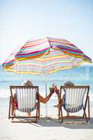 Cute mature couple lying on deckchairs