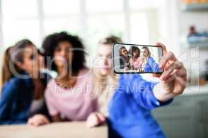 Female friends taking selfie with smart phone