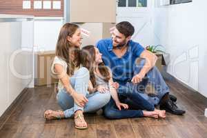 Family enjoying while sitting on floor