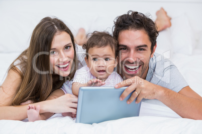 Portrait of couple with baby and tablet