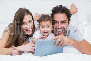 Portrait of couple with baby and tablet