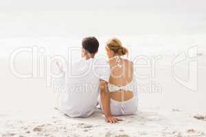 Rear view of couple sitting on the beach