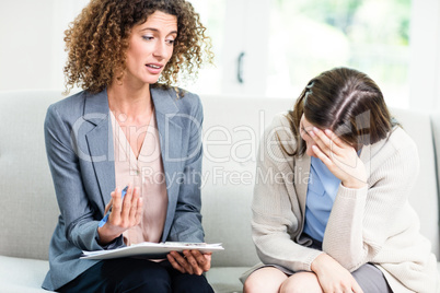 Psychologist counselling young woman at home