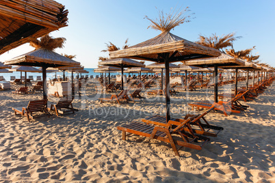 Wooden sunbeds by swimming pool