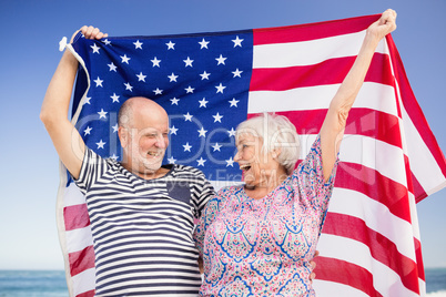 Senior couple holding american flag together