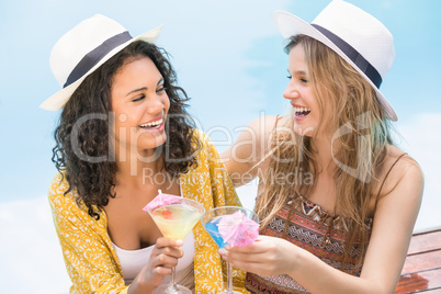 Young women having martini near pool