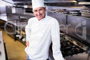 Happy male chef standing in commercial kitchen