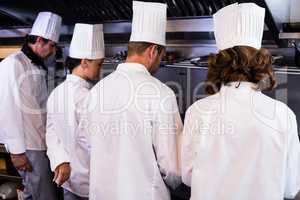 Rear view of chefs preparing food in kitchen
