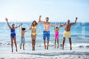 Happy family jumping on the beach