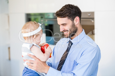 Happy businessman playing with daughter