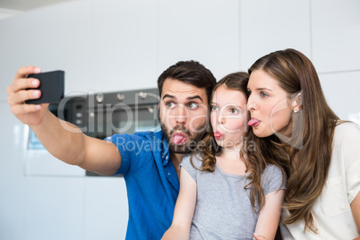 Family sticking out tongue while clicking selfie