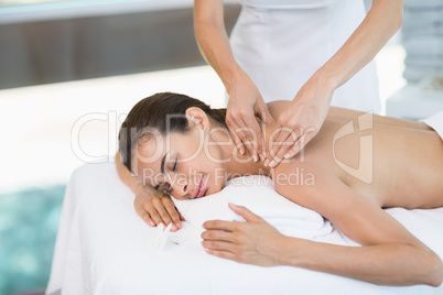 Young woman receiving massage from female masseur