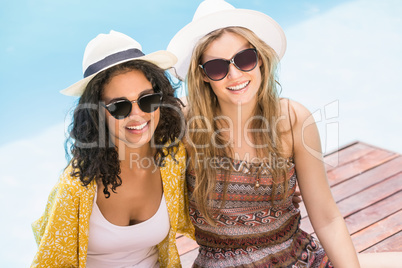 Young women wearing sunglasses having fun near pool