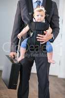 Businessman carrying daughter and briefcase