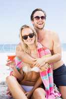 Young couple in sunglasses embracing on the beach
