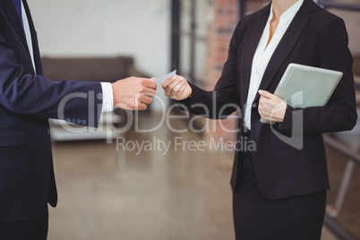 Businesswoman giving business card to client in office