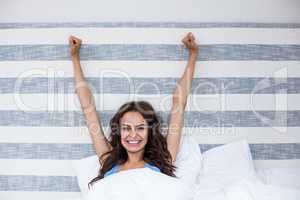 Portrait of smiling woman with arms raised