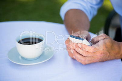 Casual businessman using smartphone and having coffee