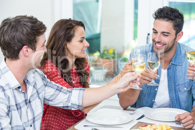 Happy friends toasting white wine